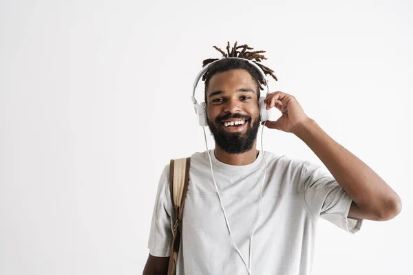 照片上是快乐的非洲裔美国人 带着耳机在白色背景下听音乐 — 图库照片