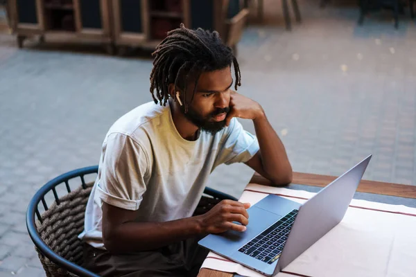 Εστιασμένος Αφροαμερικάνος Ακουστικά Που Δουλεύει Λάπτοπ Ενώ Κάθεται Καφετέρια Έξω — Φωτογραφία Αρχείου