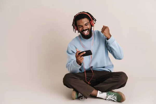 Nadšený Africký Američan Sluchátkách Pomocí Mobilu Dělat Vítěz Gesto Izolované — Stock fotografie