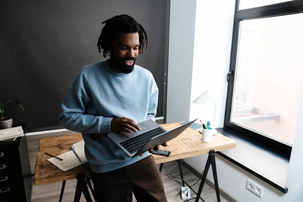 Αυτοπεποίθηση Αφροαμερικανός Που Εργάζεται Φορητό Υπολογιστή Ενώ Ακουμπά Ένα Γραφείο — Φωτογραφία Αρχείου