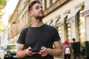 Sokakta akıllı telefon mesajları kullanan sıradan bir genç.
