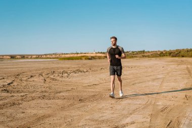 Sahilde koşan kendinden emin genç sporcu.
