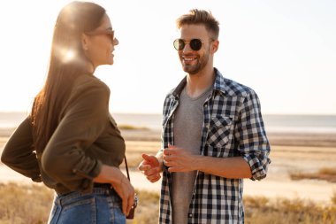 Güzel mutlu çift yazın doğada dolaşırken konuşuyor ve gülümsüyor.