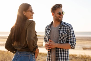 Güzel mutlu çift yazın doğada dolaşırken konuşuyor ve gülümsüyor.