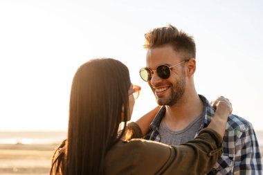 Güzel mutlu çift yazın doğada dolaşırken sarılıyor ve gülümsüyor.