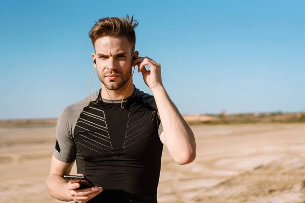 Retrato Deportista Forma Escuchando Música Con Auriculares Mientras Está Pie —  Fotos de Stock