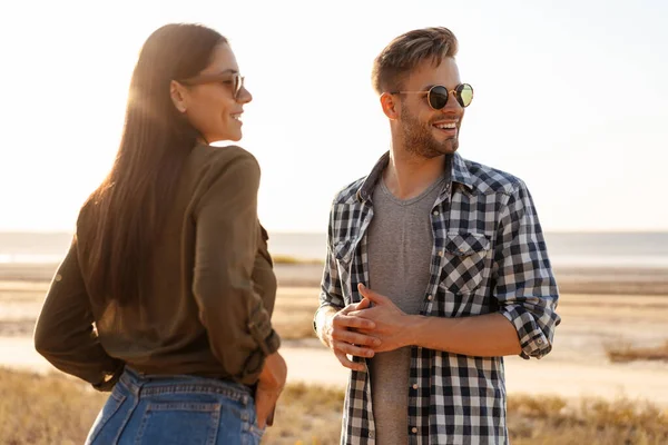 Güzel mutlu çift yazın doğada dolaşırken konuşuyor ve gülümsüyor.