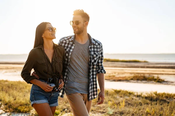 Güzel mutlu çift yazın doğada dolaşırken sarılıyor ve gülümsüyor.