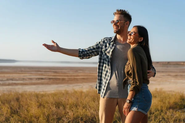 Belo Casal Feliz Abraçando Mostrando Copyspace Enquanto Passeia Natureza Verão — Fotografia de Stock