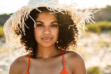 Sahilde poz veren güzel bir Afrikalı kadının fotoğrafı.