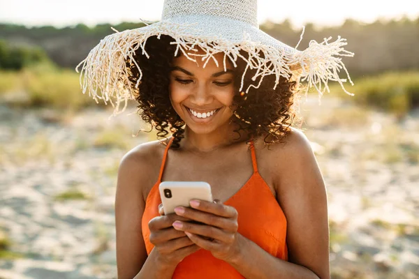 Imagem Uma Jovem Africana Muito Sorridente Usando Telefone Celular Praia — Fotografia de Stock