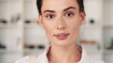 Gülümseyen bir iş kadınının yakından görüntüsü kameraya bakıyor.