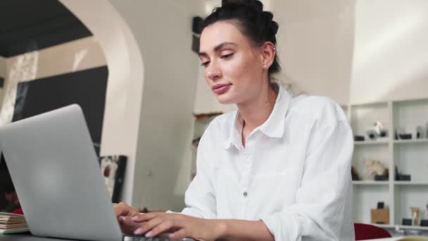 Uśmiechnięta Młoda Kobieta Pracuje Przy Laptopie Siedząc Kawiarni — Wideo stockowe