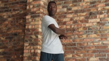 Odaklanmış bir Afrikalı Amerikalı, vücudunu içeri doğru çevirirken egzersiz yapıyor.