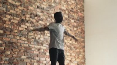 Sportif bir Afro-Amerikan adam içeride atlarken egzersiz yapıyor.