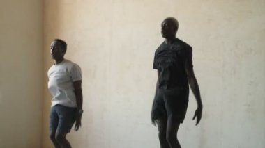 Yoğunlaşmış Afro-Amerikan erkekleri birlikte atlama egzersizleri yapıyorlar.