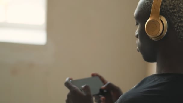 Μια Κοντινή Θέα Ενός Αφροαμερικανού Ακουστικά Χρησιμοποιεί Smartphone Του Κρατώντας — Αρχείο Βίντεο