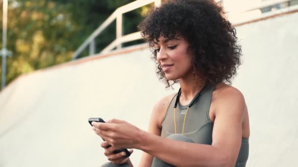 Młoda Optymistyczna Kobieta Fitness Korzystająca Telefonu Komórkowego Parku — Wideo stockowe