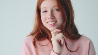 Beyaz duvar arkasında izole edilmiş güzel kızıl saçlı kız.