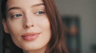 Olumlu genç bir kadın evine bakıyor.