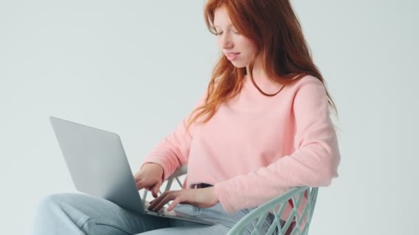 Συγκεντρωμένη Κοκκινομάλλα Όμορφο Κορίτσι Χρησιμοποιώντας Φορητό Υπολογιστή Απομονώνονται Λευκό Φόντο — Αρχείο Βίντεο