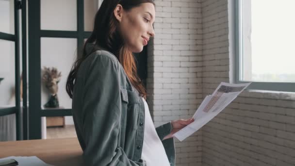 Koncentrerad Gravid Kvinna Med Dokument Inomhus Hemmet — Stockvideo