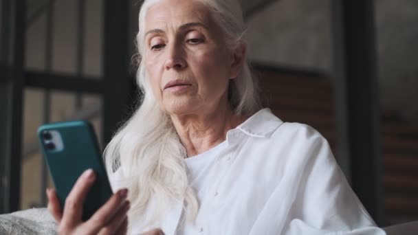 Stanca Annoiata Donna Anziana Che Utilizza Telefono Cellulare Chiuso Casa — Video Stock