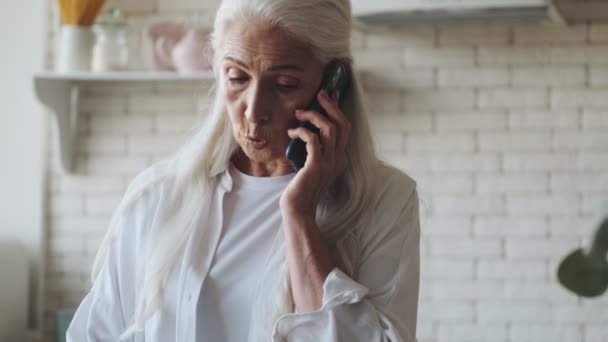 Serious Senior Woman Talking Mobile Phone Kitchen Indoors Home — Stock video