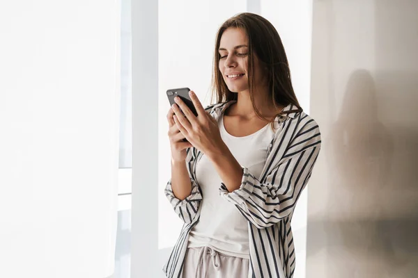 Joven Hermosa Mujer Caucásica Sonriendo Sosteniendo Teléfono Celular Casa — Foto de Stock