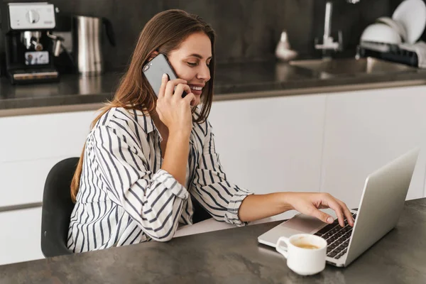 Junge Schöne Kaukasische Frau Telefoniert Und Arbeitet Hause Laptop — Stockfoto