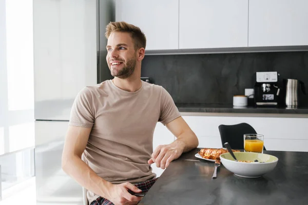 Ung Stilig Kaukasisk Man Ler Medan Äter Frukost Hemma — Stockfoto