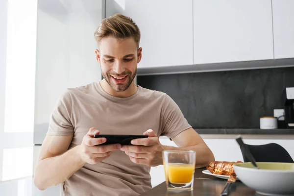 Young Handsome Caucasian Man Holding Cellphone While Having Breakfast Home — Stock Photo, Image