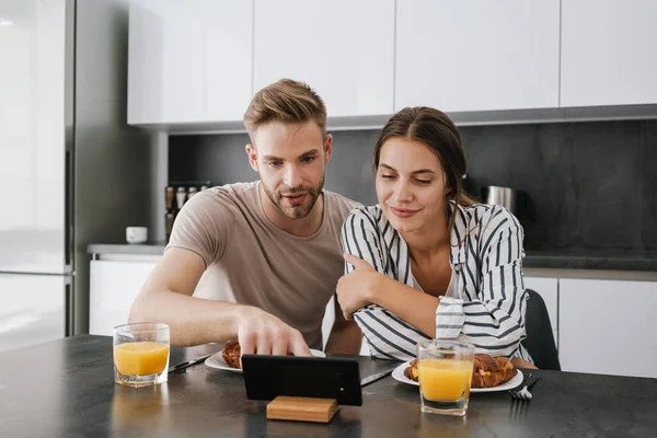 Joven Pareja Caucásica Mirando Juntos Teléfono Celular Mientras Desayunan Casa —  Fotos de Stock