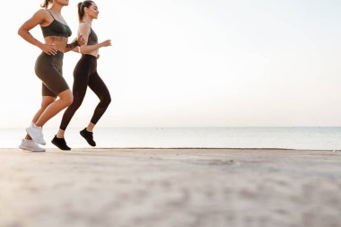 İnanılmaz güzel genç fitness sporu bayan arkadaşlar dışarıda koşuyorlar.