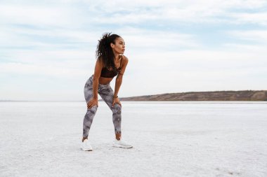 Atletik Afro-Amerikan sporcu kadının doğa üzerinde çalışırken dinlenme görüntüsü