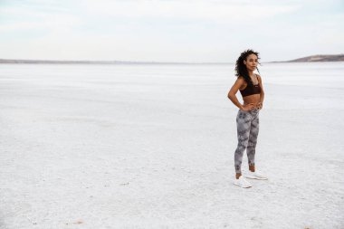 Atletik Afro-Amerikan sporcu kadın görüntüsü doğa üzerinde çalışırken ayakta duruyor