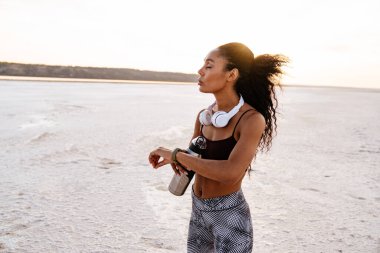 Genç Afro-Amerikan sporcu kadının, doğa üzerinde çalışırken akıllı gözlük kullanması.