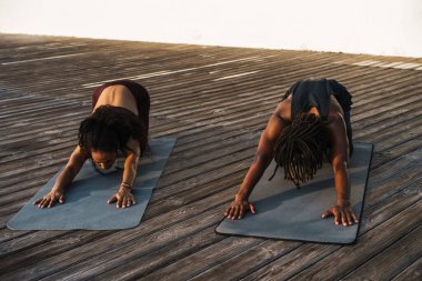 Genç, güzel, mutlu, Afro-Amerikan erkek ve kadın dışarıda egzersiz yapıyorlar.