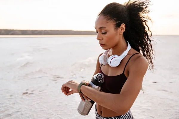 Immagine Una Giovane Sportiva Afroamericana Che Guarda Smartwatch Mentre Lavora — Foto Stock