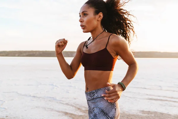 海岸を走るアフリカ系アメリカ人の自信に満ちたスポーツ女性 — ストック写真