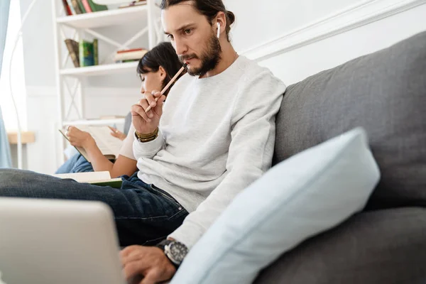 Imagen Pareja Hermosa Seria Leyendo Libro Trabajando Con Ordenador Portátil — Foto de Stock