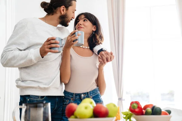 Imagen Alegre Pareja Caucásica Abrazándose Mientras Bebe Café Cocina Casera —  Fotos de Stock