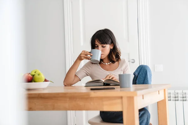 Image Serious Beautiful Woman Reading Book While Drinking Coffee Home — Stock Photo, Image