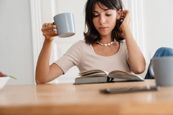 Image Serious Beautiful Woman Reading Book While Drinking Coffee Home — 图库照片