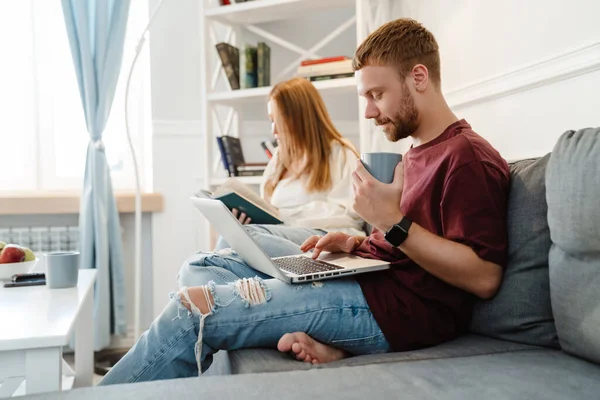 Imagen Pareja Jengibre Centrado Leer Libro Uso Computadora Portátil Mientras — Foto de Stock