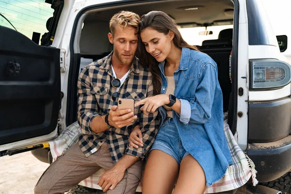 Hermosa Pareja Sentada Parte Trasera Del Coche Usando Teléfonos Inteligentes — Foto de Stock