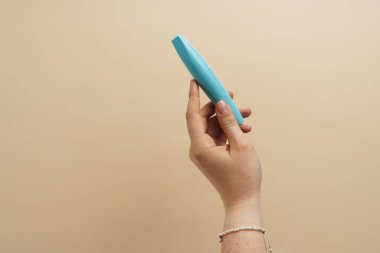 Arka planda rimel tutan kadının eli izole.