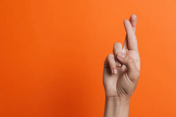 Close up of woman's fingers showing crossed fingers for good luck isolated