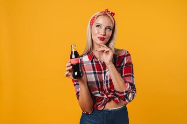 Sodayla poz veren ve sarı arka planda izole edilmiş güzel bir poster kızı.