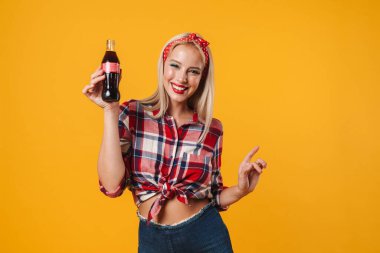 Sodayla poz veren mutlu bir poster kızı resmi ve sarı arka planda izole edilmiş yukarı doğru işaret eden bir parmak.